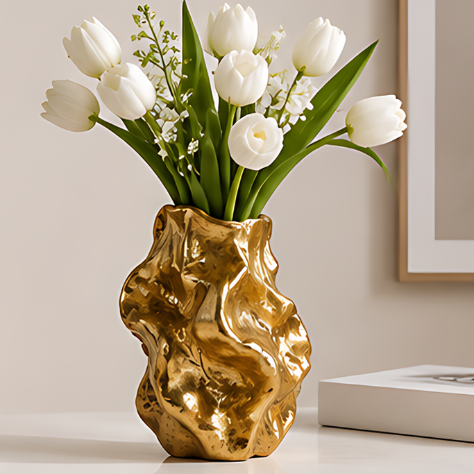 Glossy gold-toned sculptural vase with flowing contours, styled with white tulips and green foliage