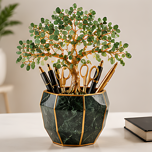 Green leafy tree pen holder with gold-toned trunk and dark green marble-look geometric container, shown with stationery